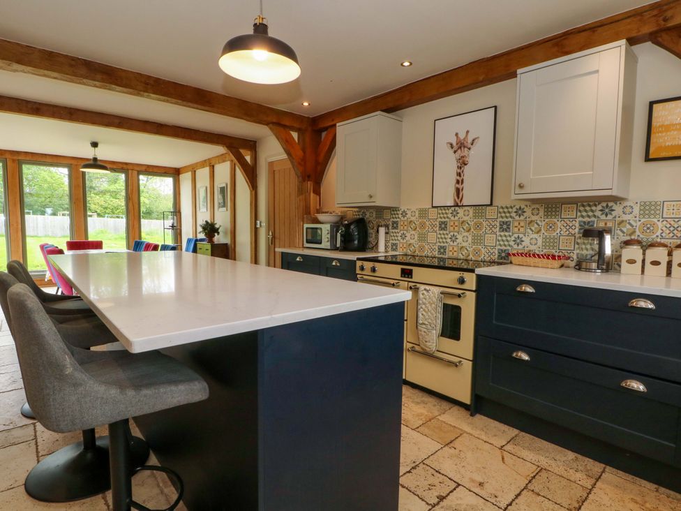 A kitchen with white cabinets and a kitchen island at Gayton Stables in Heswall