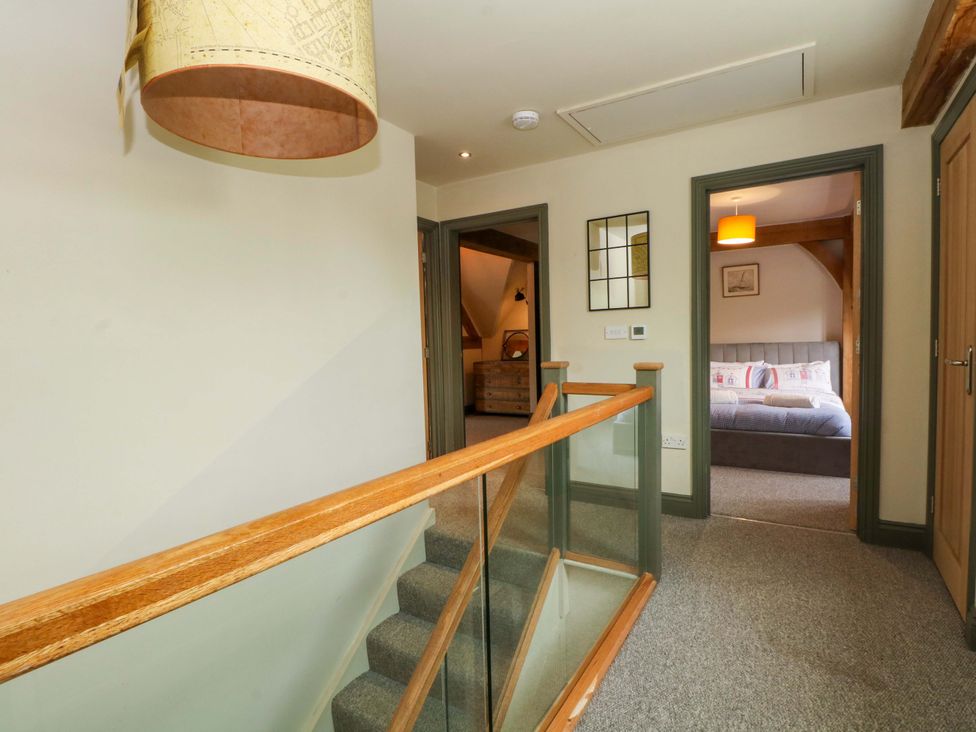 A hallway with a staircase and a view of a bedroom at Gayton Stables in Heswall