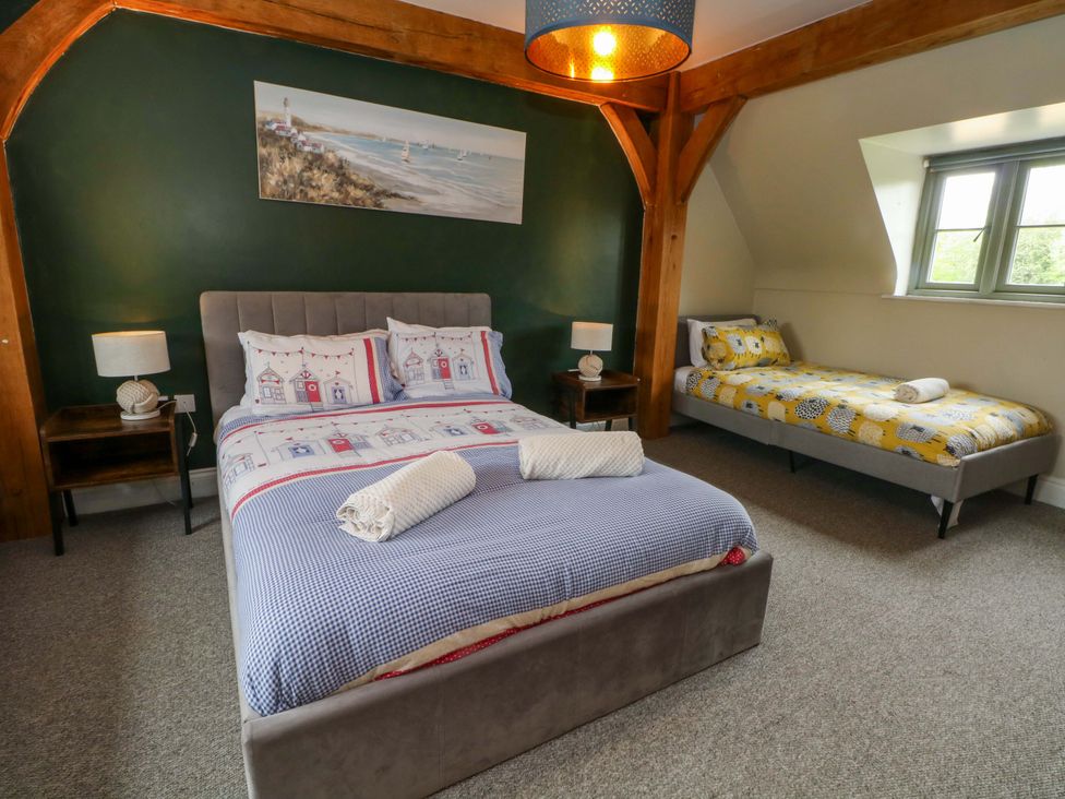 A bedroom with a double bed and single bed at Gayton Stables in Heswall