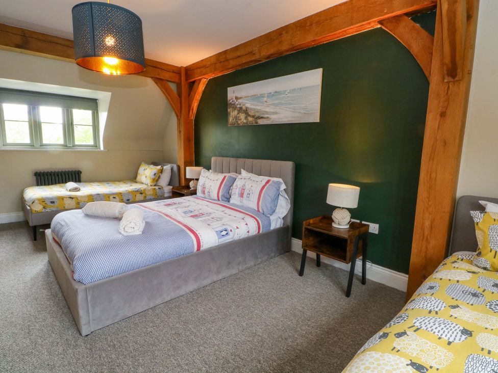 A bedroom with two beds and a window at Gayton Stables in Heswall