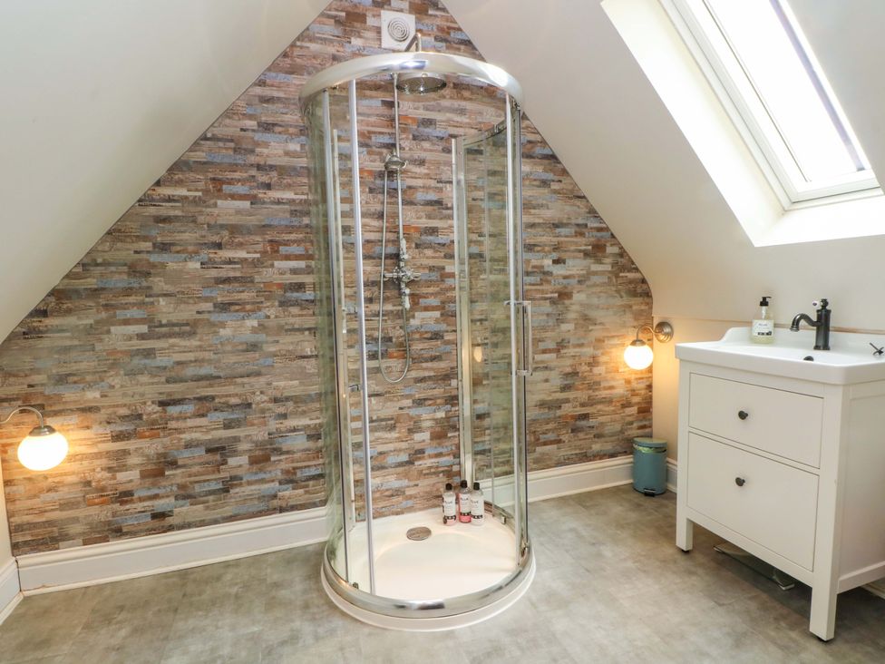 A bathroom with a shower and a sink at Gayton Stables in Heswall