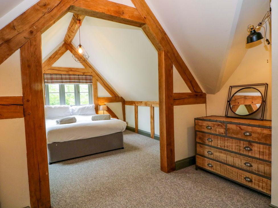 A bedroom with a bed and a dresser at Gayton Stables in Heswall
