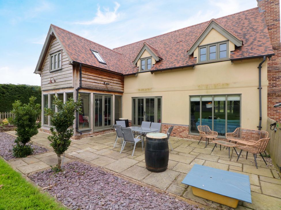 An outdoor patio area with furniture and a barrel at Gayton Stables in Heswall