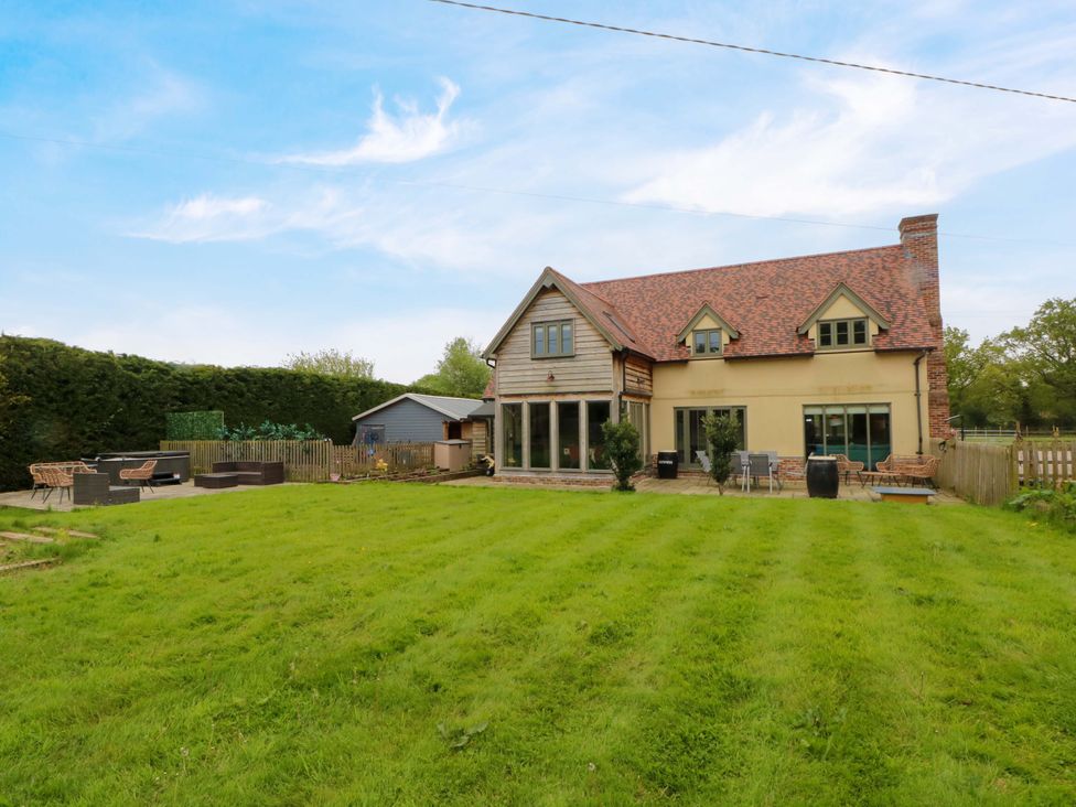 A garden with a house and patio area at Gayton Stables in Heswall