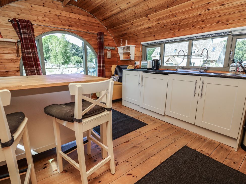 A kitchen with bar stools and cabinets at Gayton Stables in Heswall