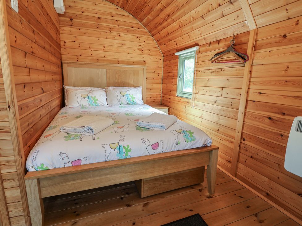 A bedroom with a bed and window at Gayton Stables in Heswall