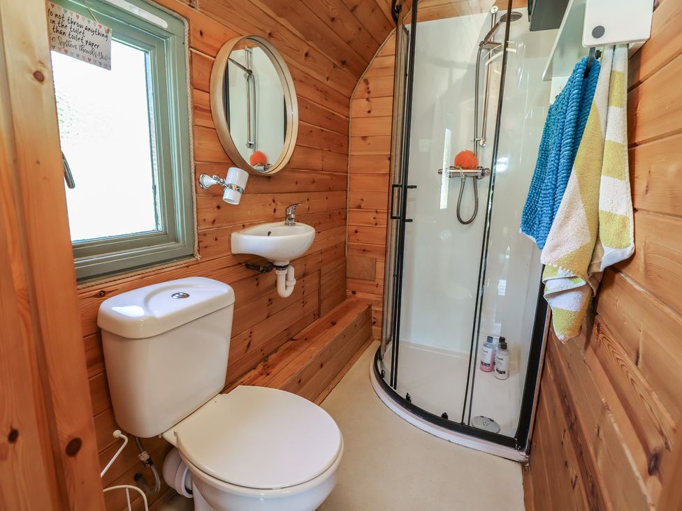 A bathroom with a shower, sink, and toilet at Gayton Stables Heswall