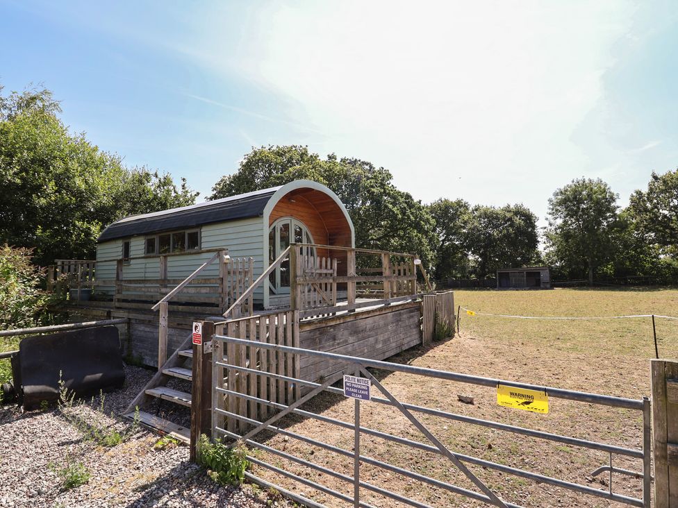 An outdoor area with a shed and a fenced grass space at Gayton Stables in Heswall