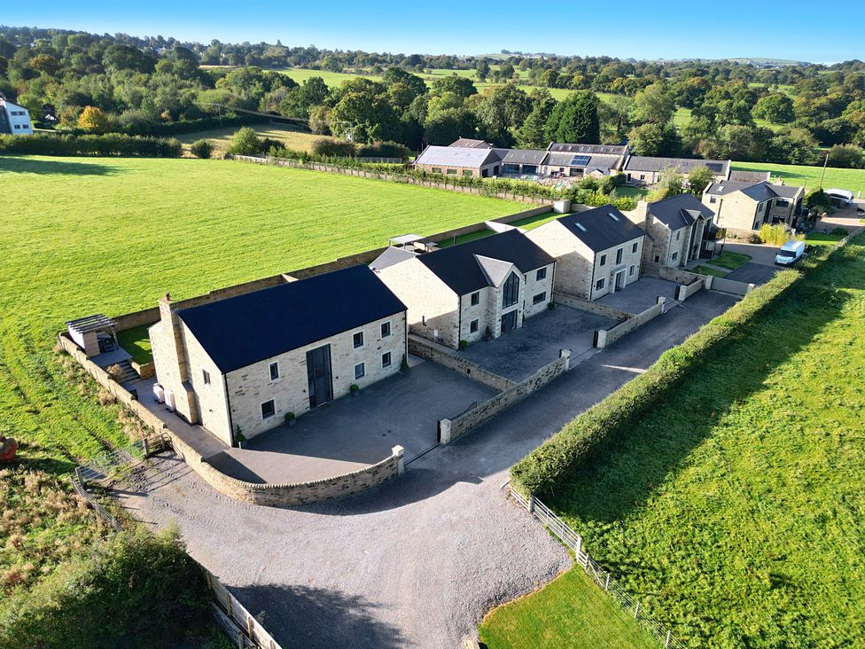 An aerial view of multiple buildings and a green field at Mylstone House in Langho, Lancashire