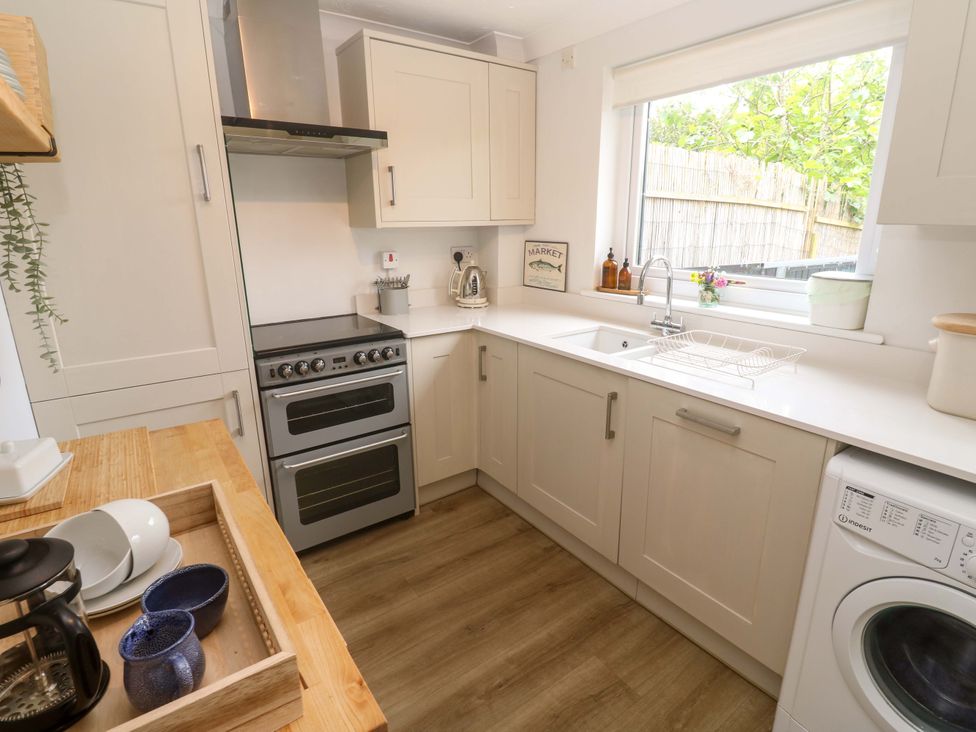 A kitchen with cabinets stove and sink at Trelowen in St Issey near Padstow