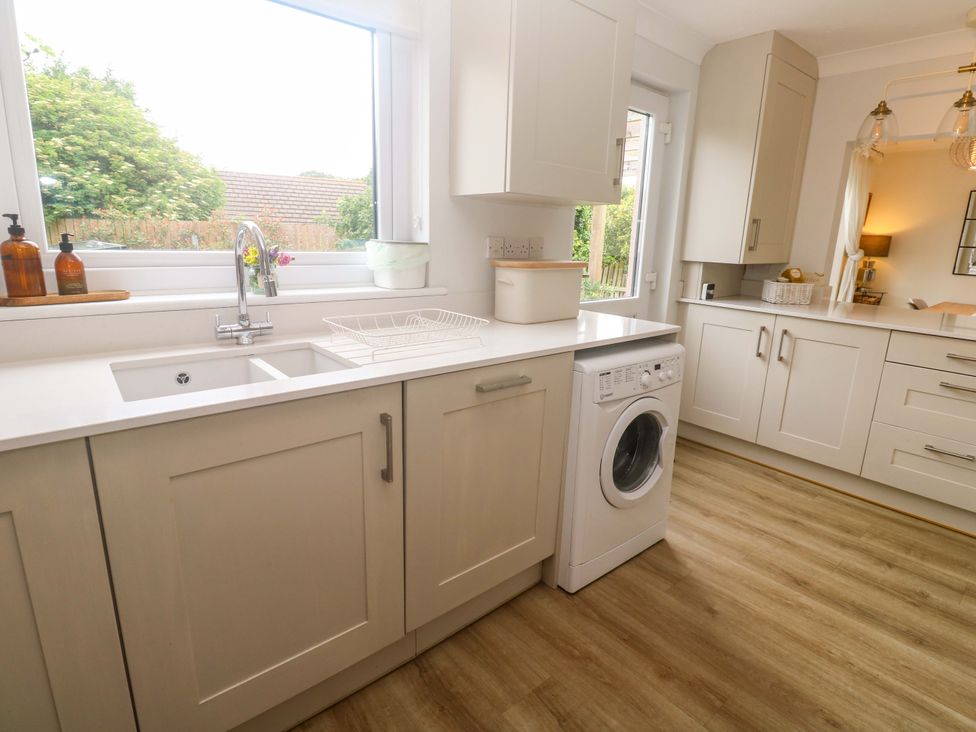 A kitchen with a sink and washing machine at Trelowen St Issey near Padstow