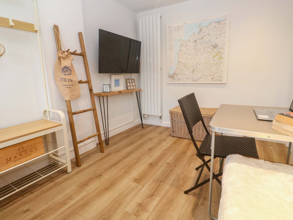 An office with a desk chair and a television at Trelowen St Issey near Padstow