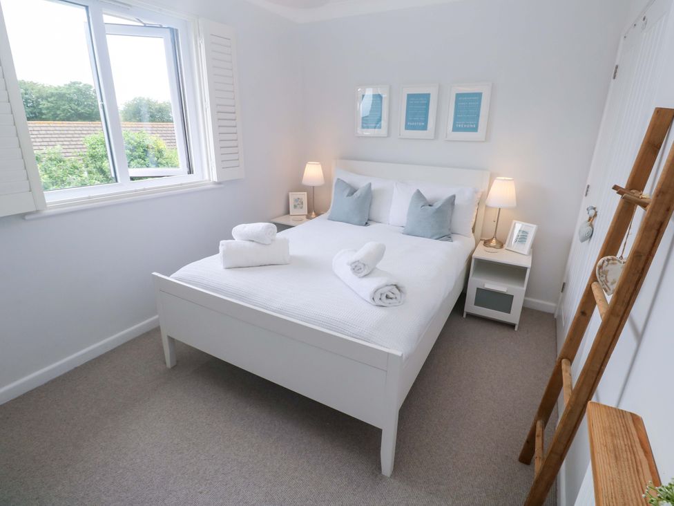 A bedroom with a bed and window at Trelowen in St Issey near Padstow