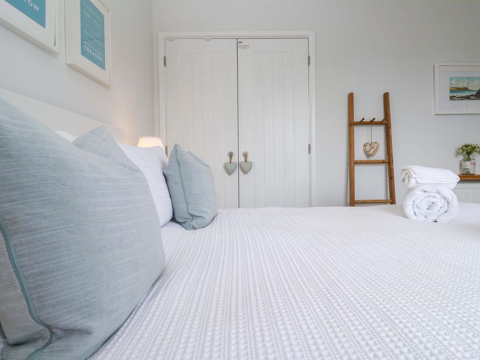 A bedroom with a bed and decorative items at Trelowen St Issey near Padstow
