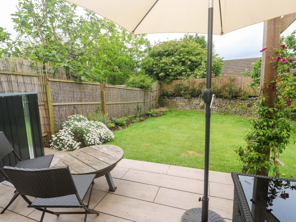 A garden with seating and an umbrella at Trelowen St Issey near Padstow