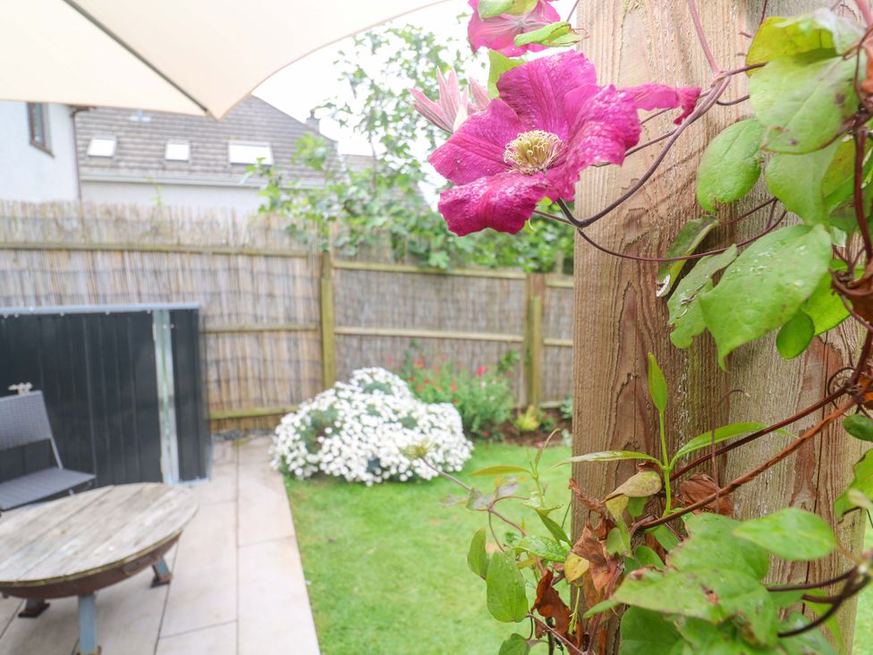A garden with a flower and seating area at Trelowen in St Issey near Padstow