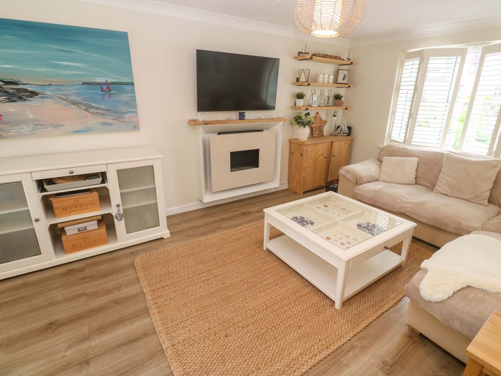 A living room with a sofa and a coffee table at Trelowen in St Issey near Padstow