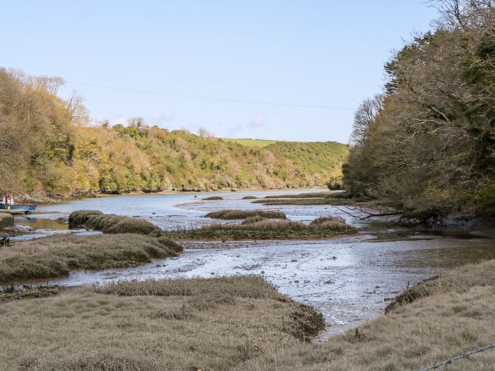 A river with mudflats and trees beside it at Trelowen in St Issey near Padstow