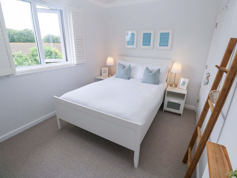 A bedroom with a bed and nightstand at Trelowen St Issey near Padstow