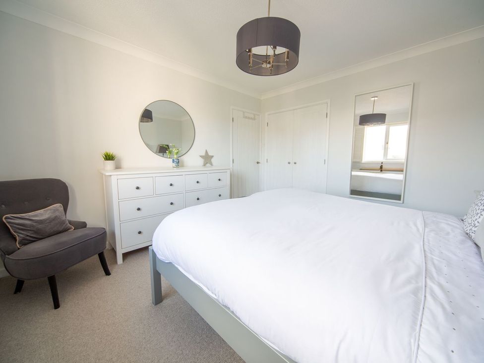 A bedroom with a bed and dresser at Trelowen St Issey near Padstow