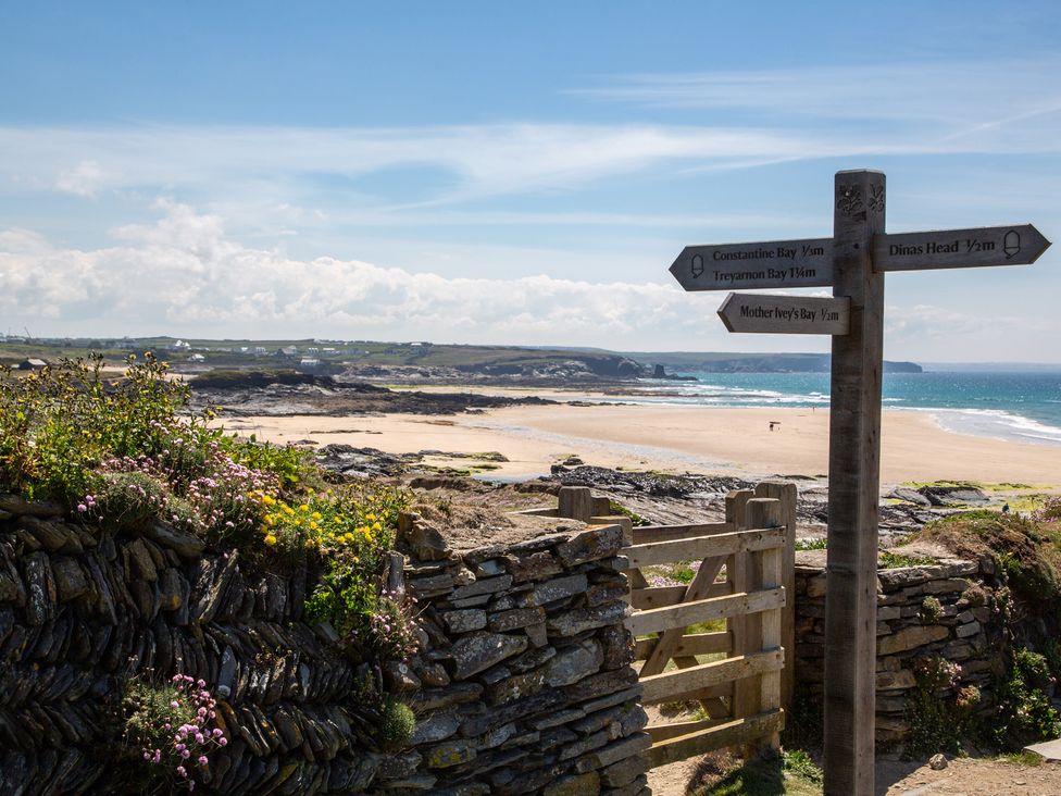 A beach scene with a signpost showing directions at Trelowen St Issey near Padstow