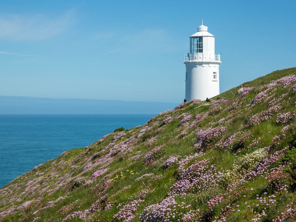 A lighthouse on a hill with flowers overlooking the sea at Trelowen in St Issey near Padstow