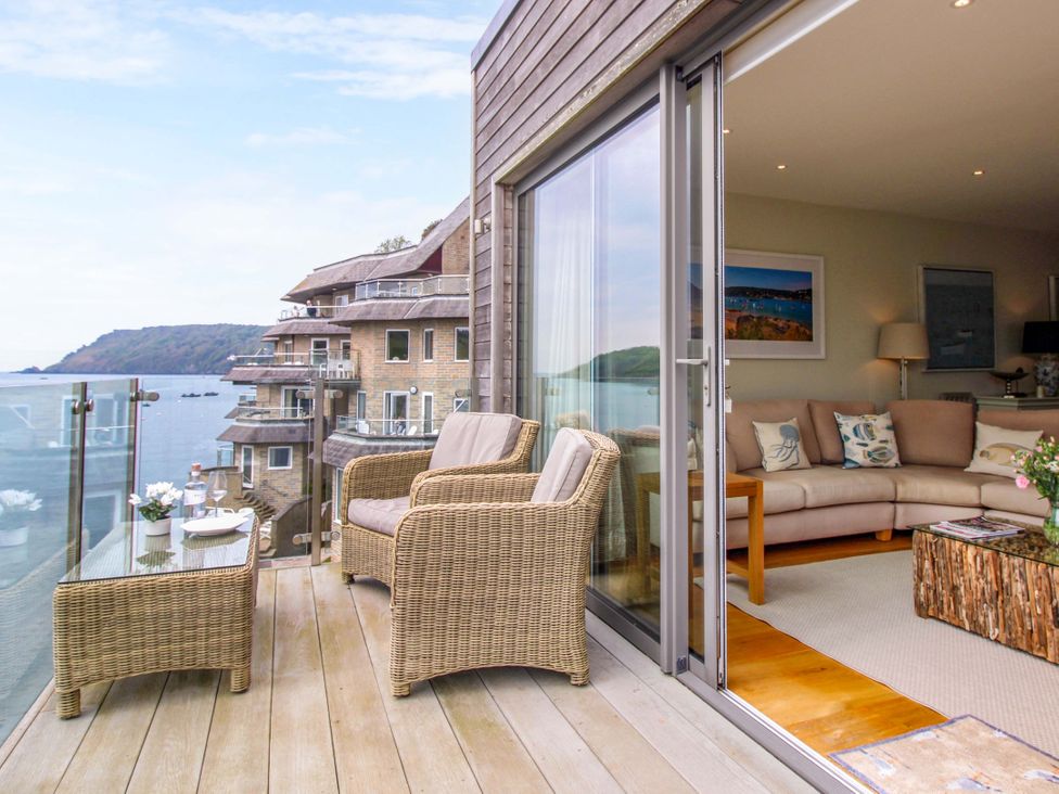 A living room with sliding door and seating area at Villa 1, Estura Salcombe