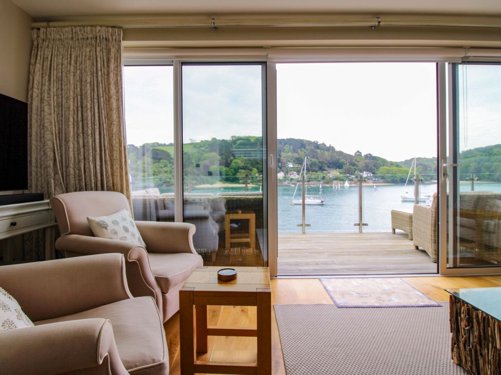 A living room with a sliding door and view at Villa 1, Estura in Salcombe