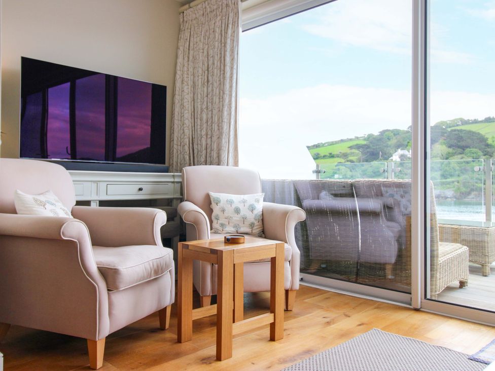 A living room with a television and two armchairs at Villa 1, Estura in Salcombe