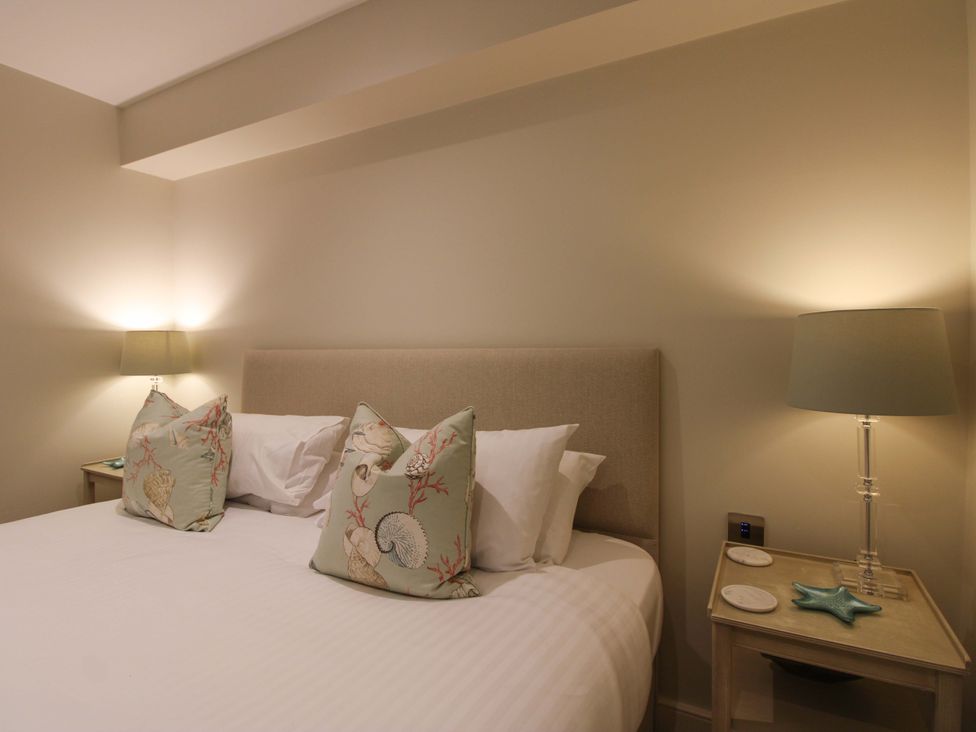 A bedroom with a bed and nightstand at Villa 1, Estura Salcombe