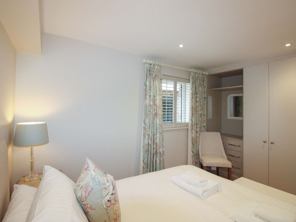 A bedroom with a bed and lamp at Villa 1, Estura Salcombe