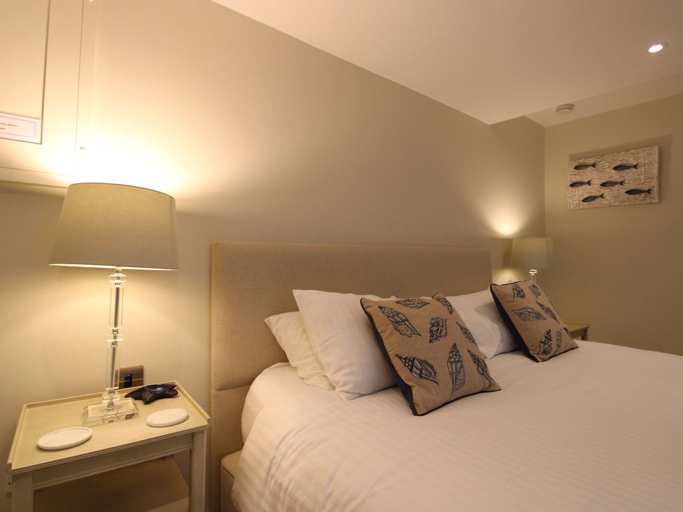 A bedroom with a bed and bedside table at Villa 1, Estura Salcombe