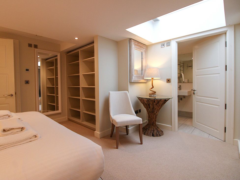 A bedroom with a bed and a mirror at Villa 1, Estura Salcombe