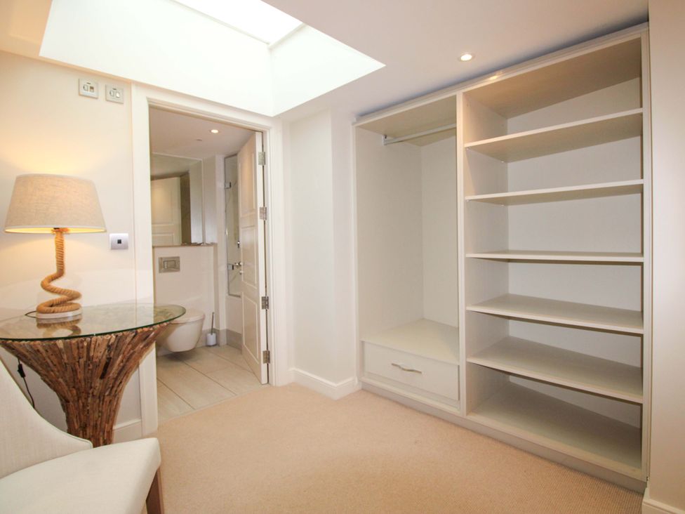 A bedroom with a closet and a lamp at Villa 1, Estura, Salcombe