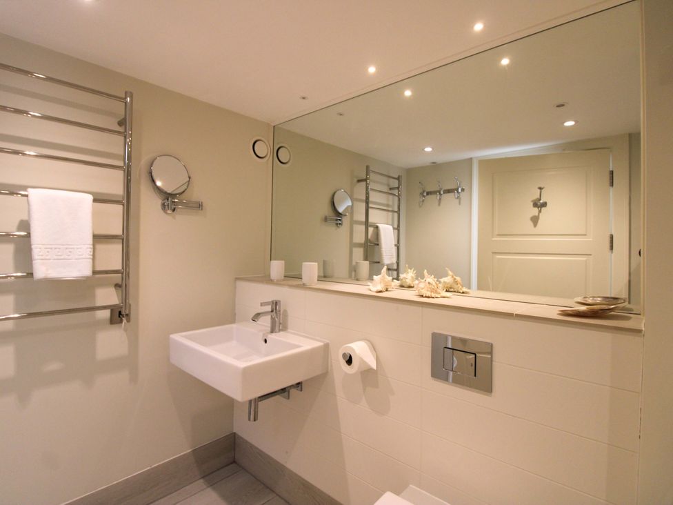 A bathroom with a sink and towel rack at Villa 1, Estura, Salcombe
