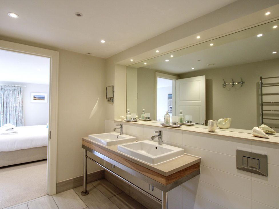 A bathroom with double sinks and a mirror at Villa 1, Estura Salcombe