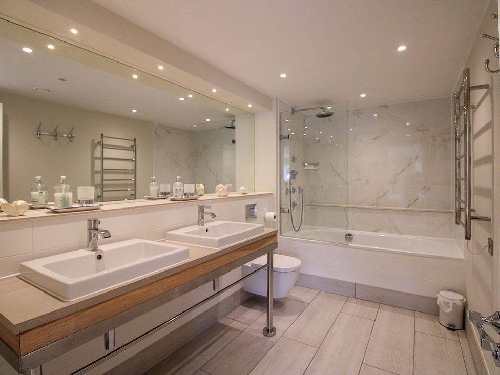 A bathroom with a double sink and bathtub at Villa 1, Estura in Salcombe