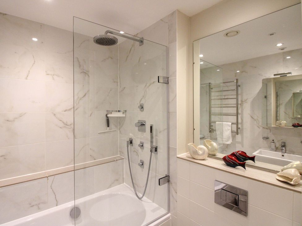 A bathroom with a shower and bathtub at Villa 1, Estura in Salcombe