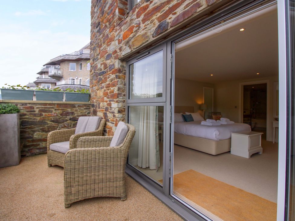 A balcony with chairs overlooking a bedroom at Villa 1, Estura in Salcombe