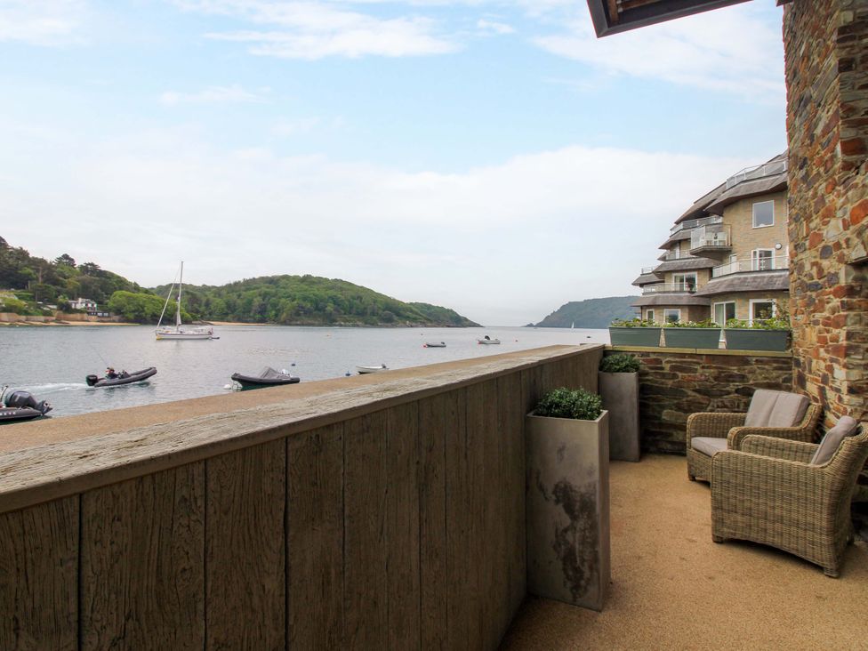A balcony with chairs and planters overlooking the river at Villa 1, Estura in Salcombe