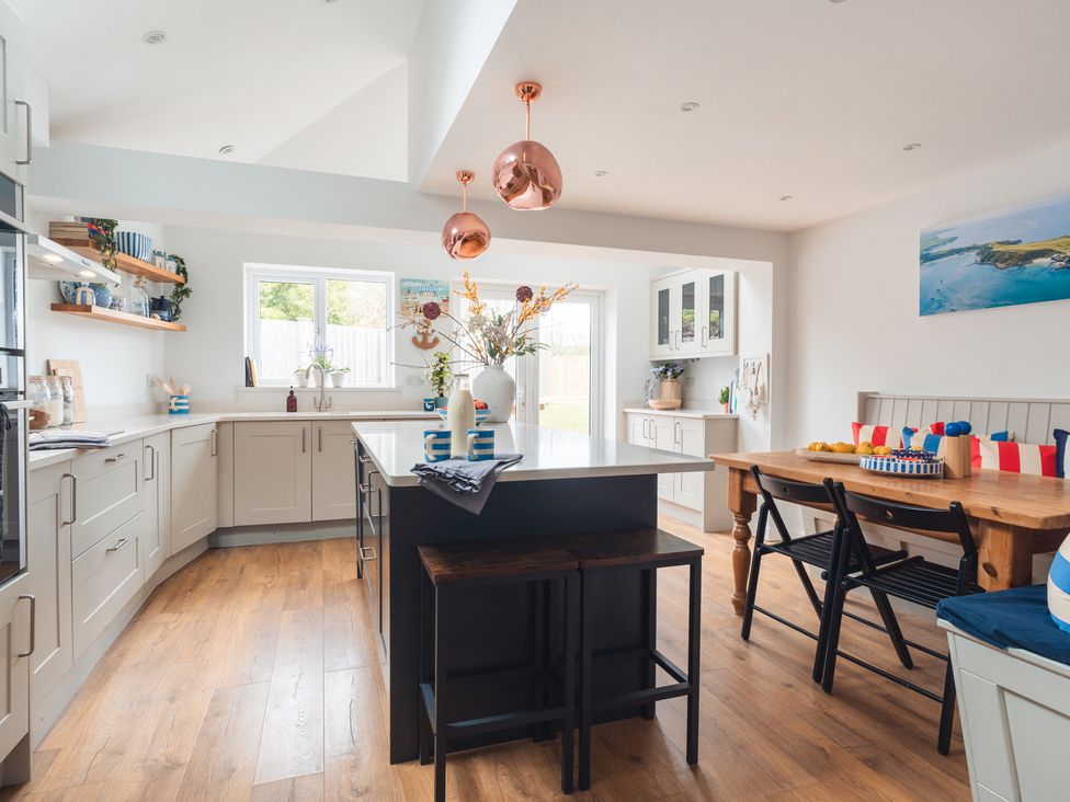 A kitchen with an island and table at Gerallt in Morfa Nefyn