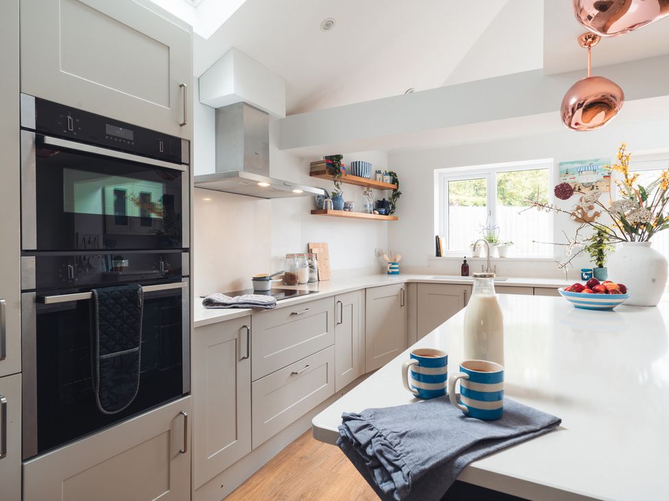 A kitchen with appliances and fruit on the countertop at Gerallt in Morfa Nefyn