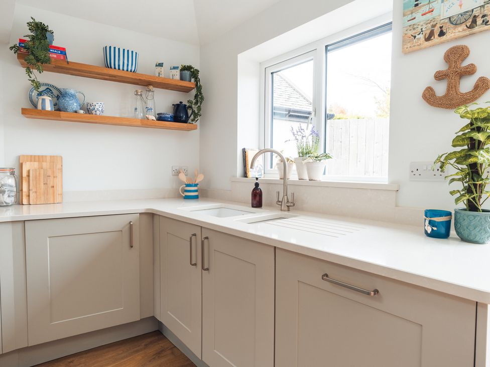 A kitchen with wooden shelves and a sink at Gerallt in Morfa Nefyn