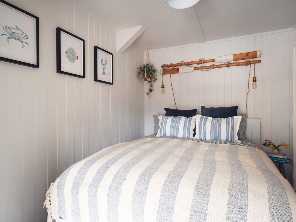 A bedroom with a bed and wall decor at Gerallt in Morfa Nefyn