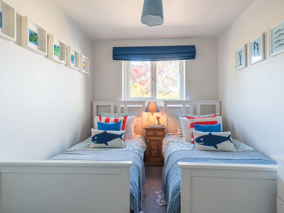 A bedroom with two single beds and a lamp at Gerallt in Morfa Nefyn
