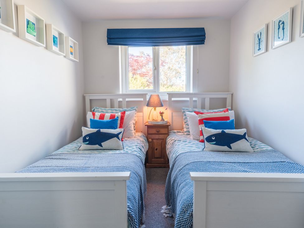 A bedroom with two single beds and a nightstand at Gerallt in Morfa Nefyn