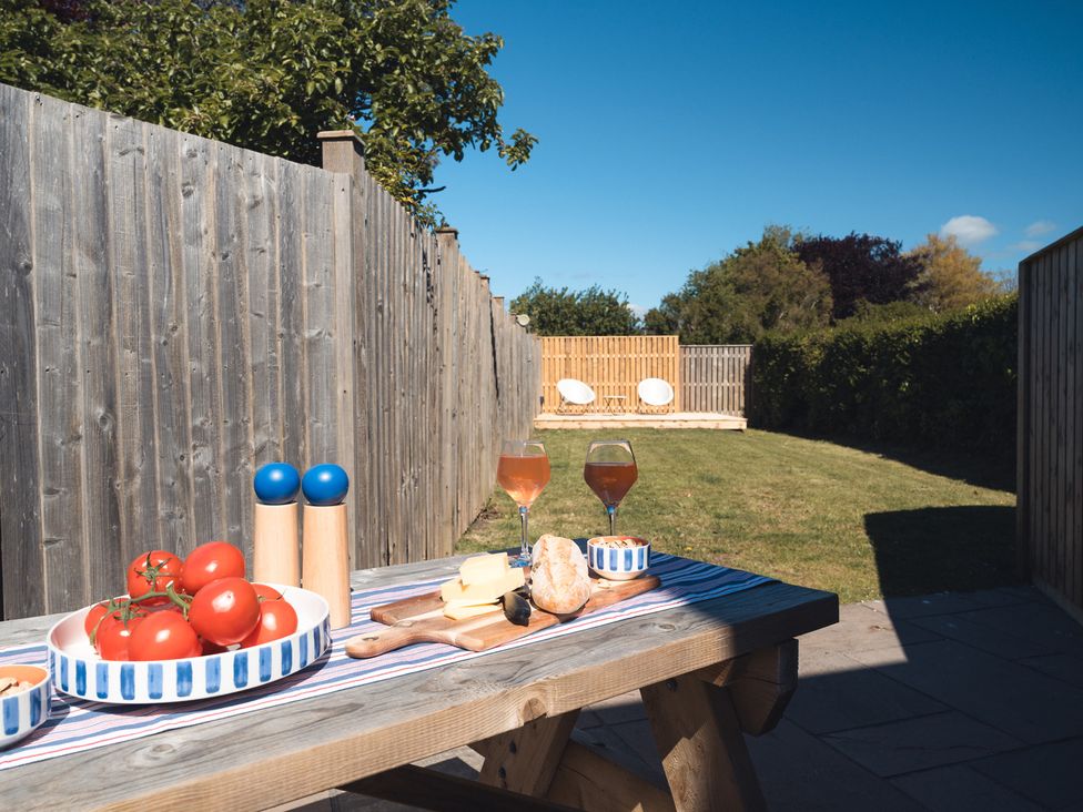 A garden with a table set for outdoor dining at Gerallt in Morfa Nefyn