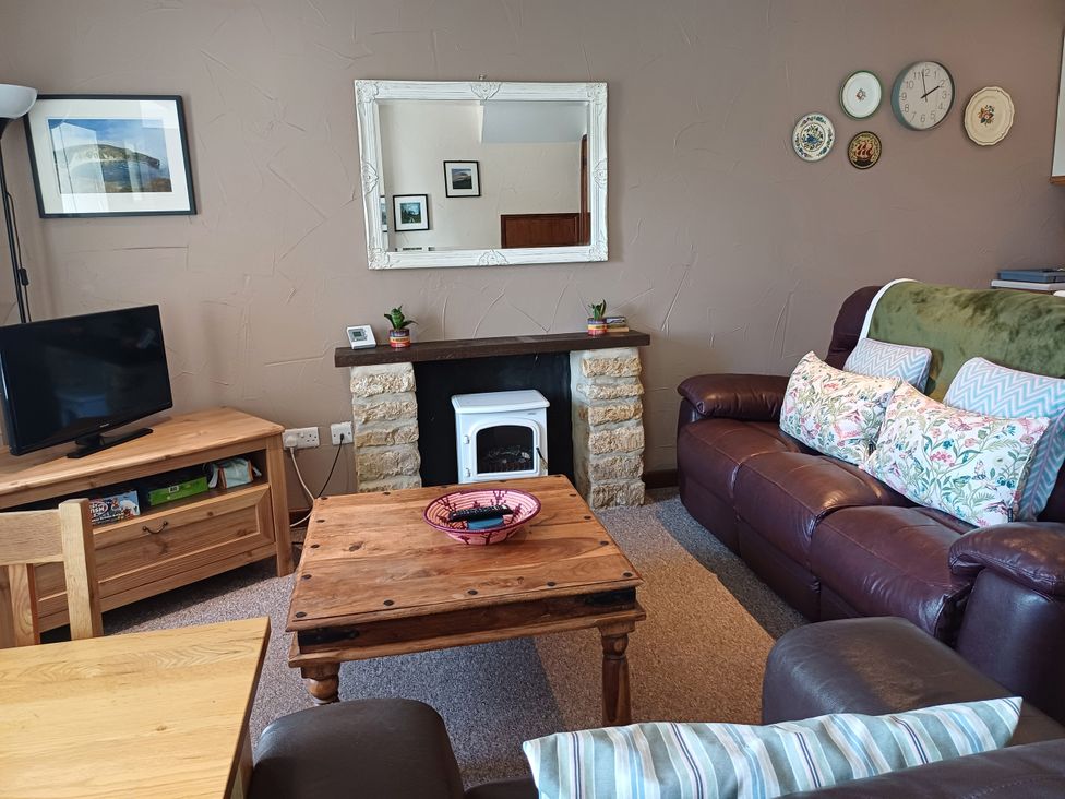 A living room with a sofa and television at The Linhay in Bridport
