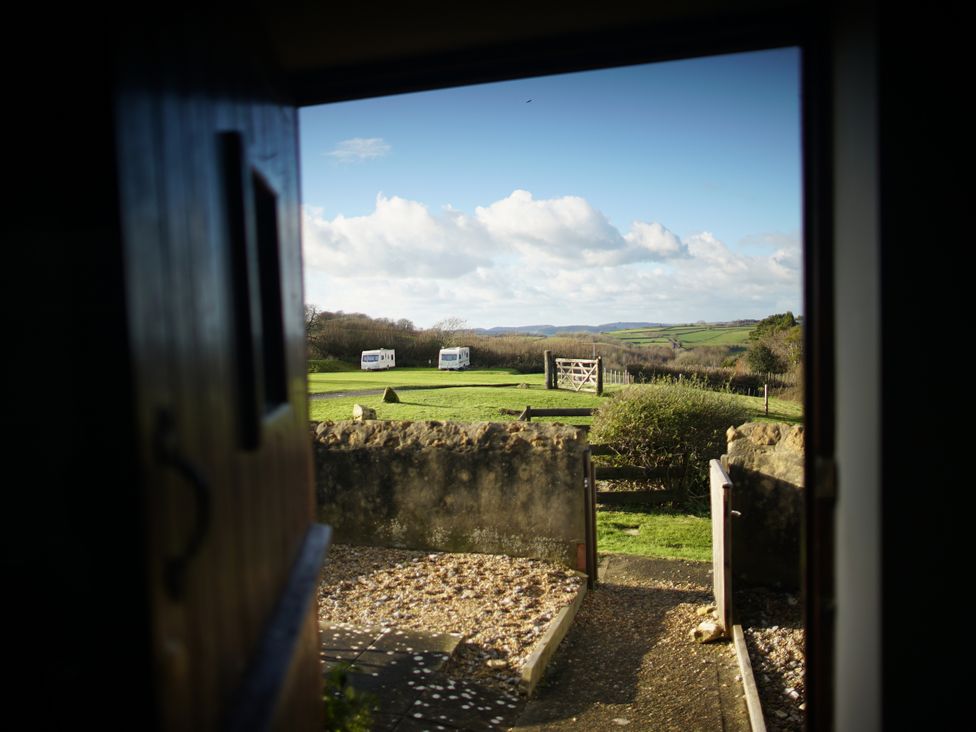 A view of a field with caravans from a door at The Sty in Bridport