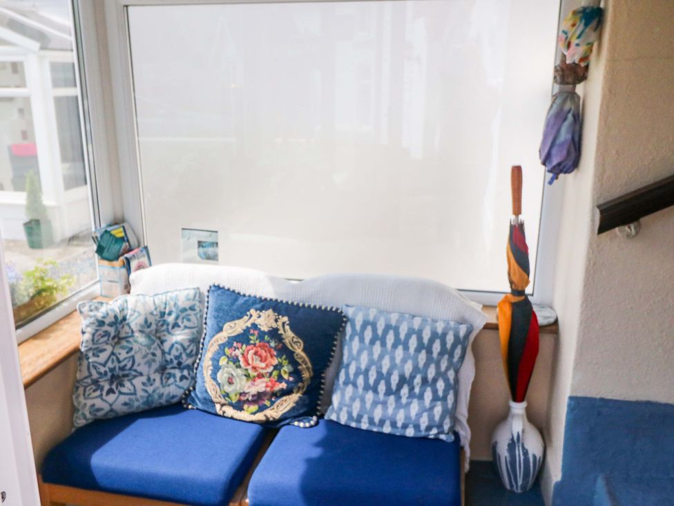 A conservatory with a sofa and cushions at Waterfall House, Dunmanway, County Cork